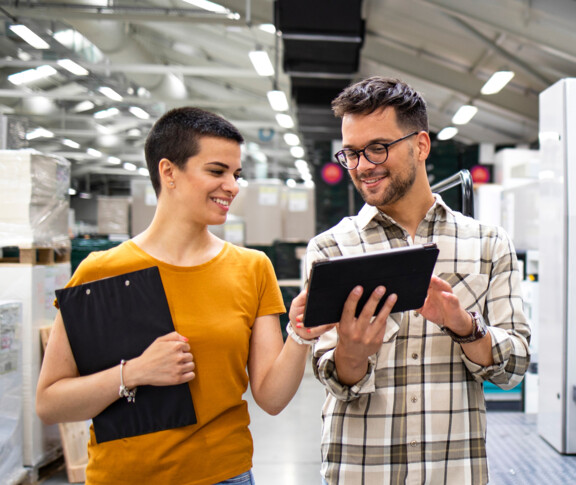 Discussing service delivery industrial production site colleagues male female modern devices
